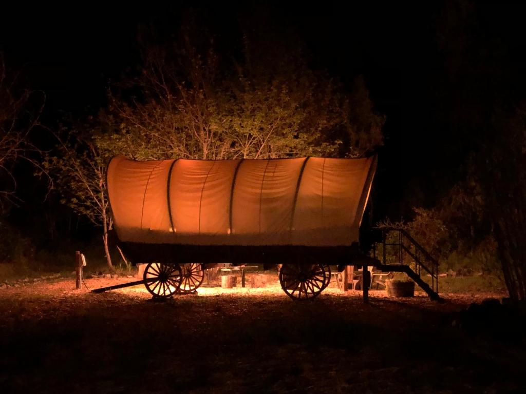 a boat on a cart in a field at night at Cozy Wild West Covered Wagon next to River in Grants Pass
