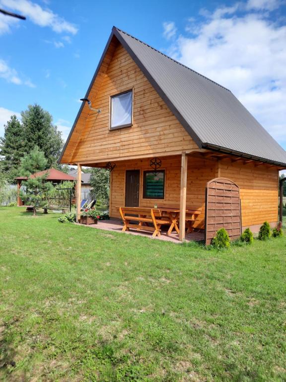 uma cabana de madeira com uma mesa de piquenique no quintal em Domek Forest em Zwierzyniec