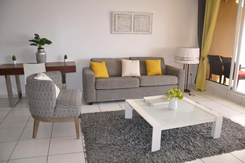 a living room with a couch and a table at Appartement standing 2 chambres vue mer RES TAHIRI 3 in Punaauia