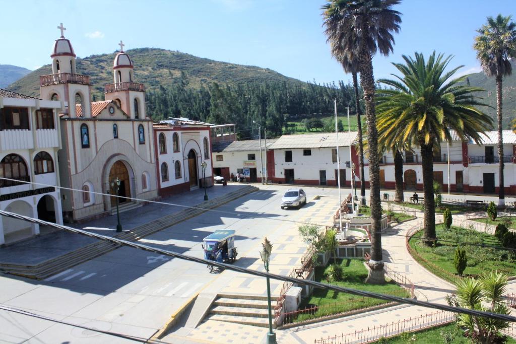 une église avec des palmiers en face d'une rue dans l'établissement Huascarán Inn, à Mancos
