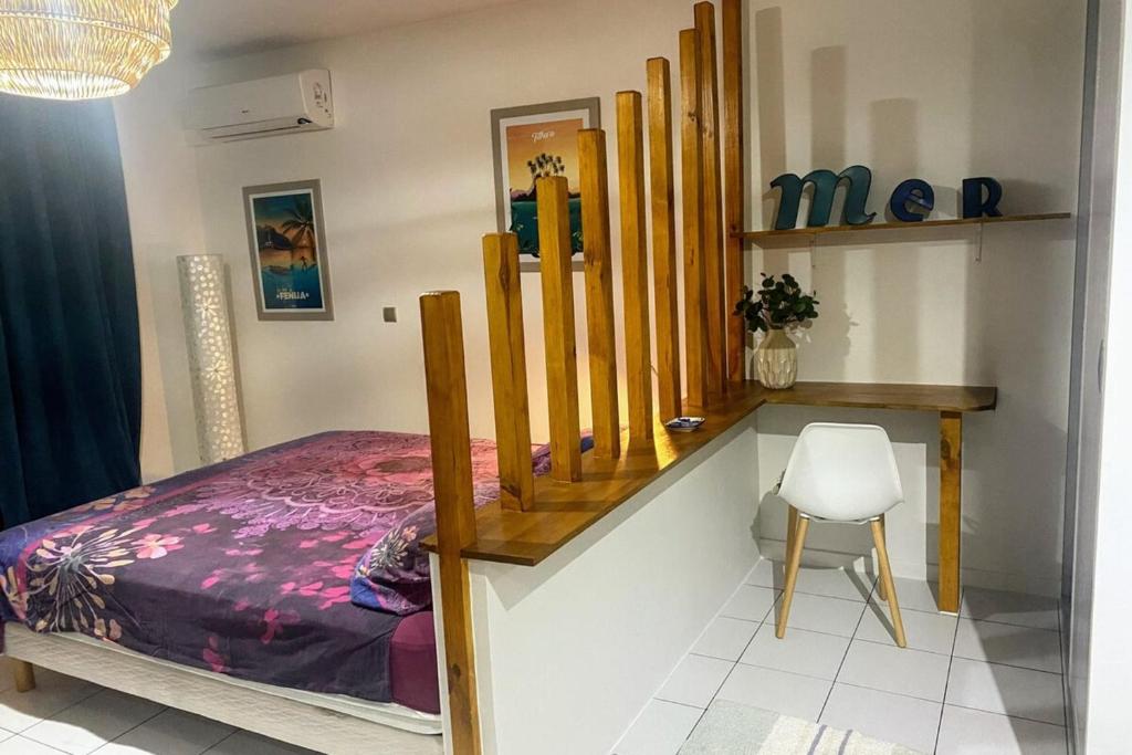 a bedroom with a bed and a desk and a chair at Grand Studio Les Horizons Papeete in Papeete