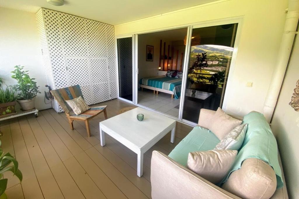 a living room with a couch and a table at Grand Studio Les Horizons Papeete in Papeete