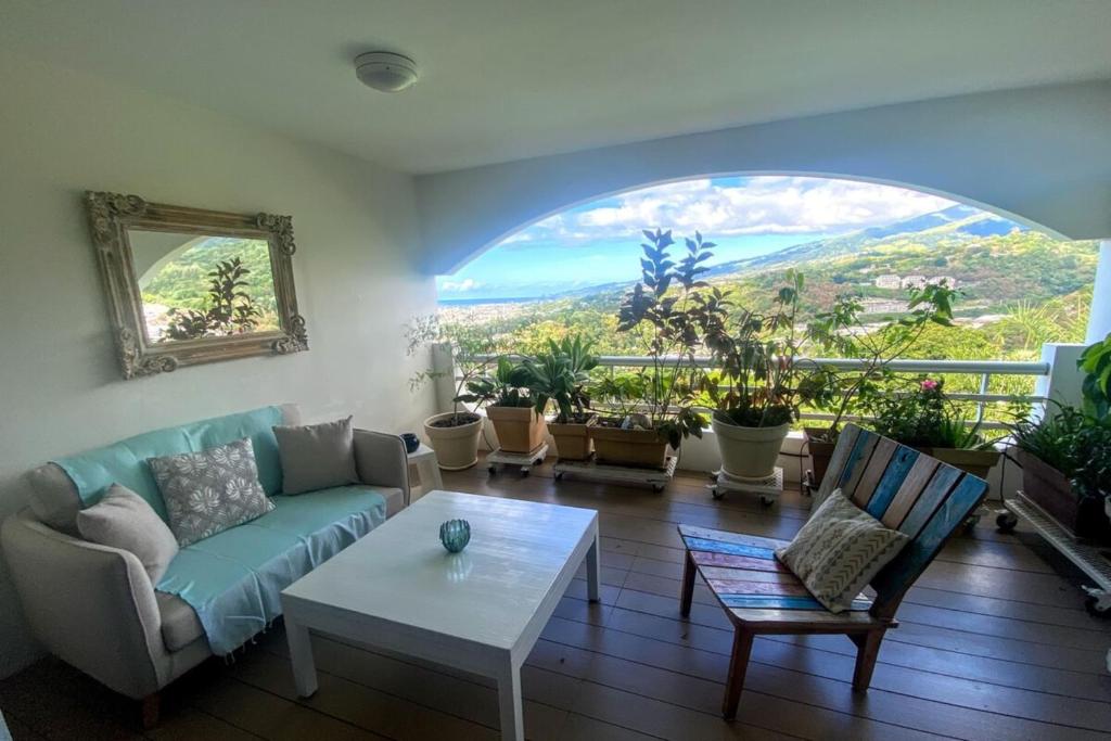 a living room with a couch and a table at Grand Studio Les Horizons Papeete in Papeete