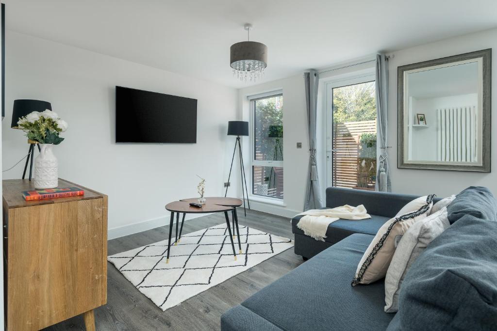 sala de estar con sofá azul y TV en Luxury Brighton Apartments, en Brighton & Hove