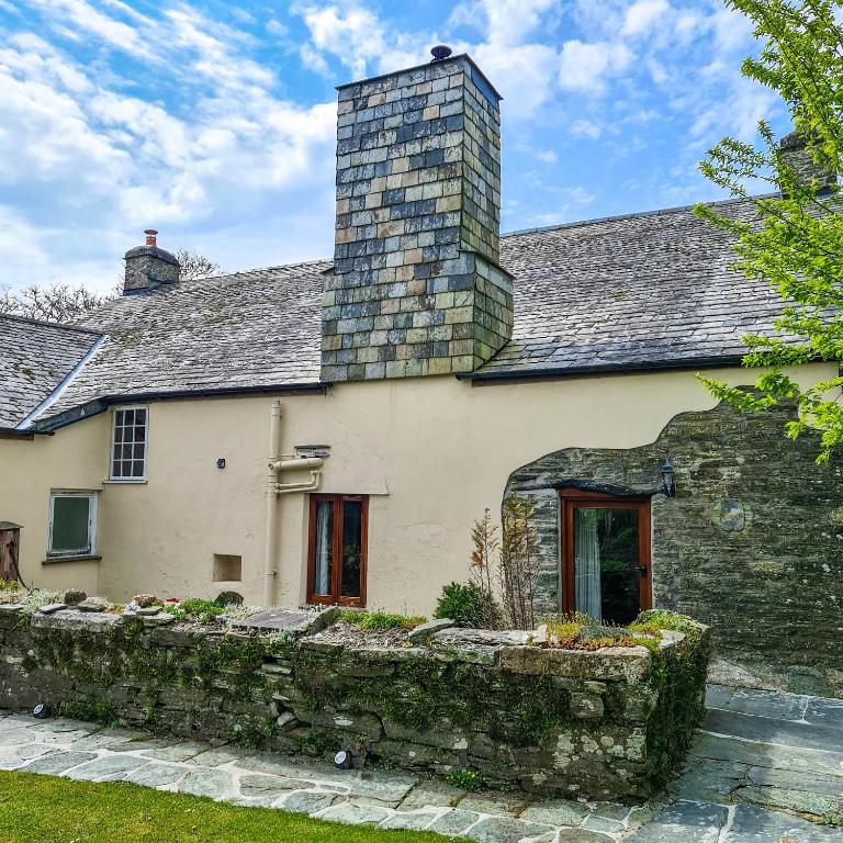 a stone house with a chimney on top of it at Ta Mill Cottages & Lodges - Pump Cottage in Launceston