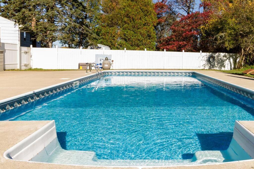 uma piscina com água azul num quintal em Private Heated Pool - Sparkling Oasis Near Newport & Navy, 4bd 3ba em Middletown