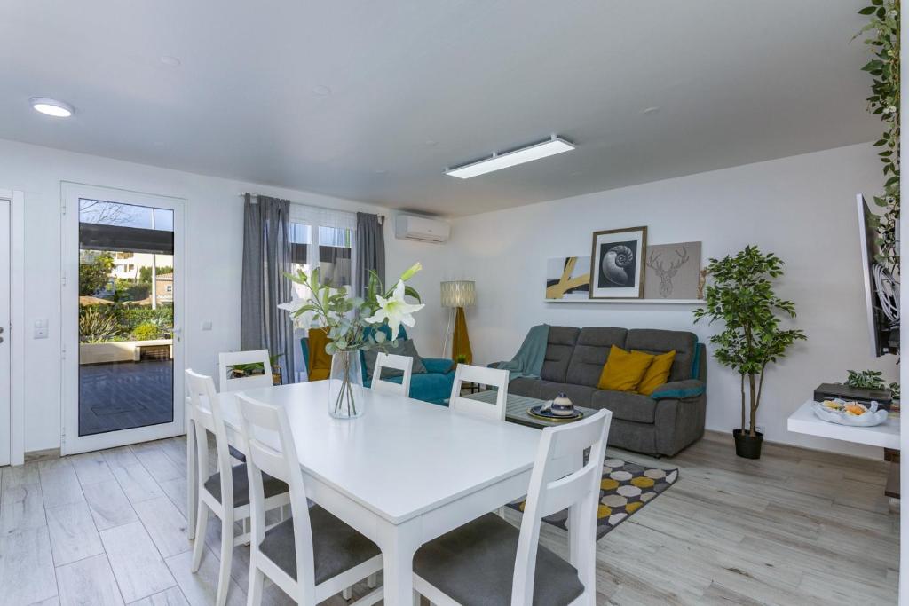 a living room with a white table and chairs at Vilar do Jardim - Terrace and Pool - Vilamoura in Quarteira