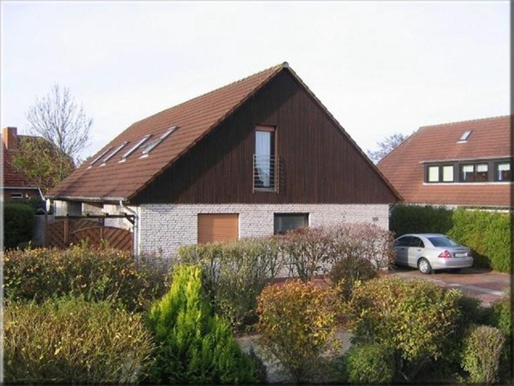 a house with a car parked in front of it at Haus Harle 50202 Ferienwohnung Harle 2 in Harlesiel