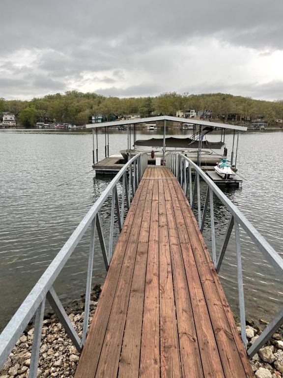 a wooden dock with a boat on the water at Loft , boat dock, 2 bedrooms , pet friendly in Gravois Mills