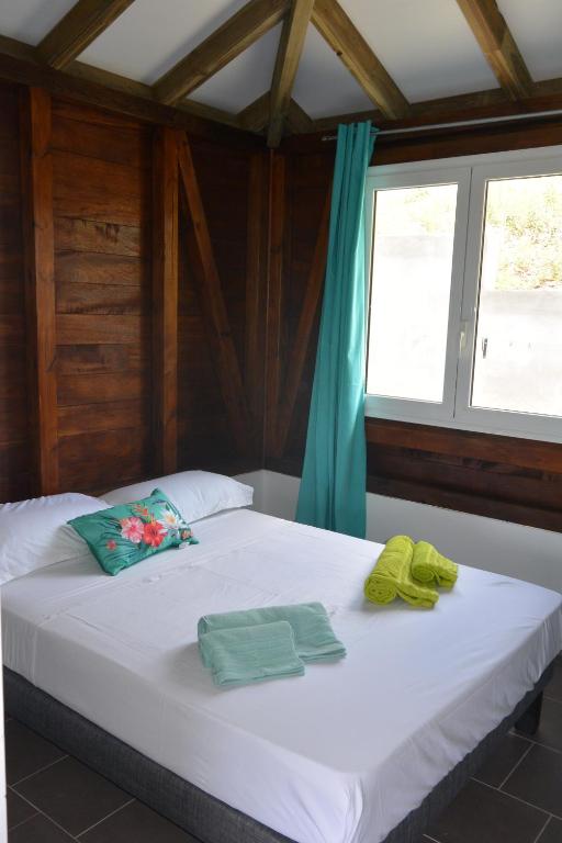 łóżko w pokoju z dwoma ręcznikami w obiekcie Maison Ste Anne/Marin Piscine personnelle vue sur mer w mieście Le Marin