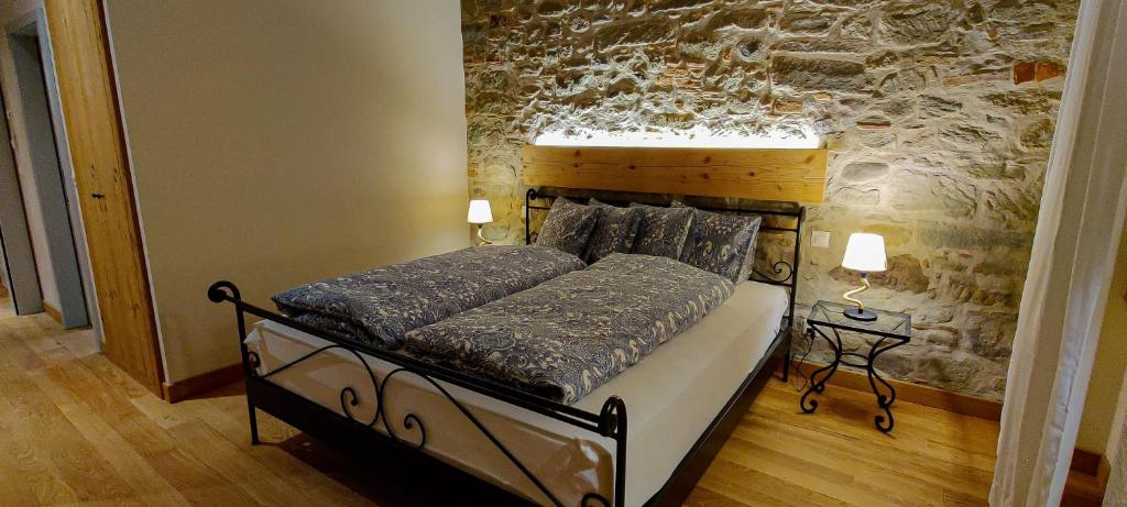 una camera con un letto in una stanza con un muro di Hôtel St-Georges Romont a Romont