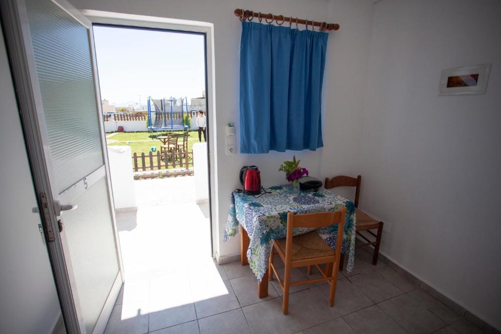 a room with a table and a blue curtain at Villa Bel Passo Apartments in Kefalos