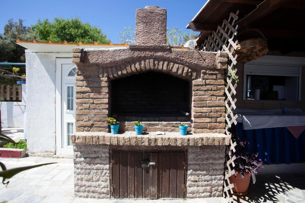a brick oven with a door in a yard at Villa Bel Passo Apartments in Kefalos
