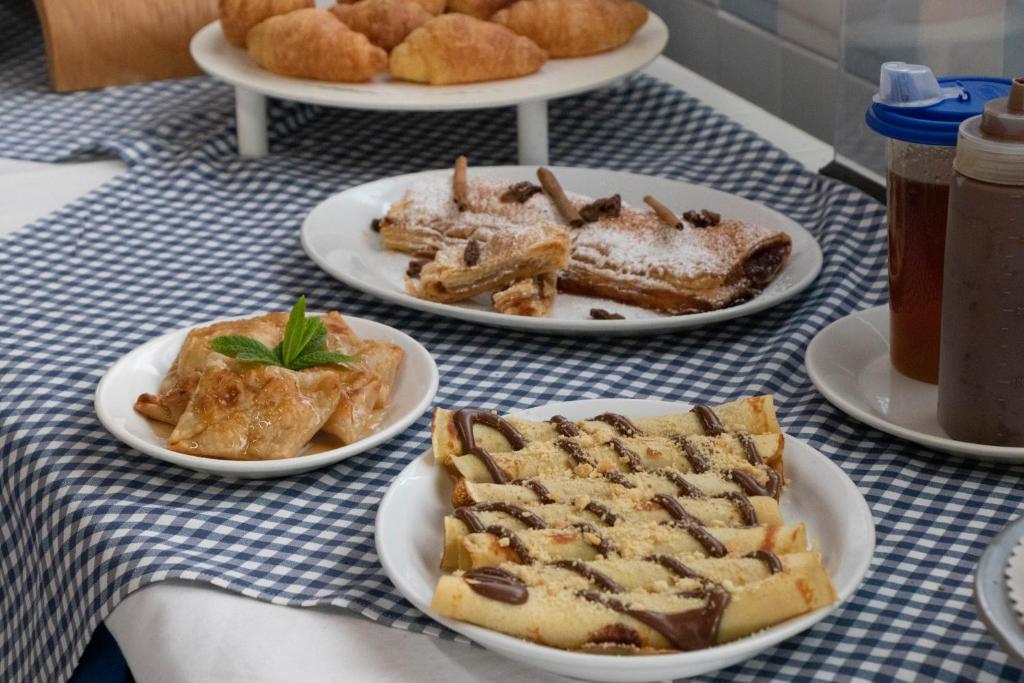 a table with plates of pastries and desserts on plates at Villa Bel Passo Apartments in Kefalos