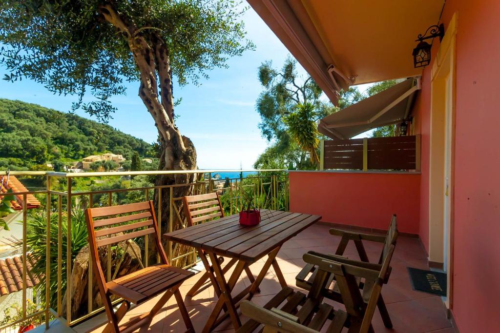 a table and chairs on a balcony with a view of the ocean at Tramonto Maisonettes & Suites in Parga