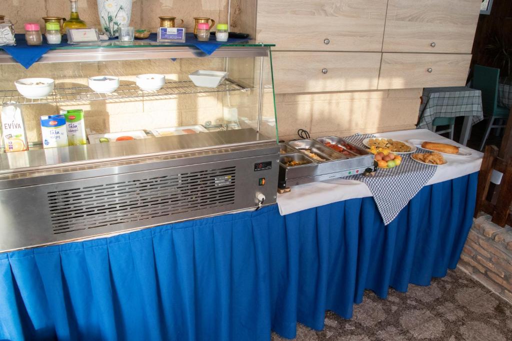 a buffet table with a blue curtain and food at Villa Bel Passo Apartments in Kefalos