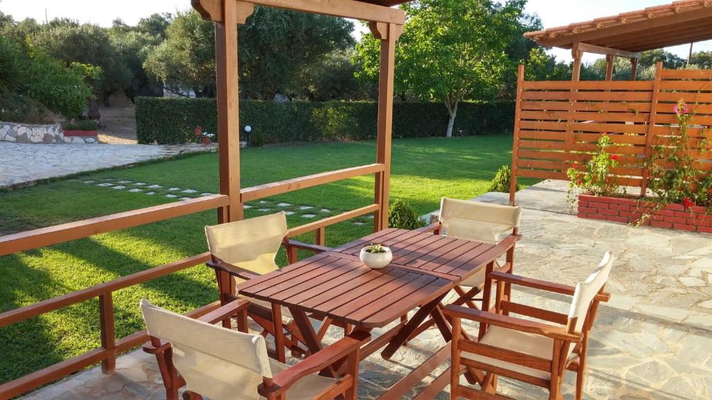 a wooden table and chairs on a patio at Dora Apartments in Tragaki