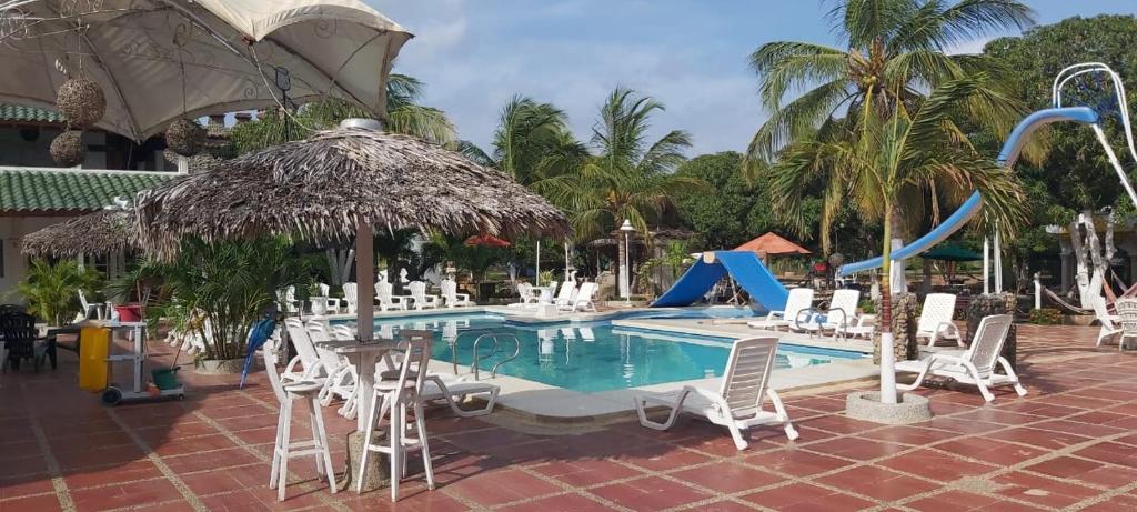 a pool with chairs and a slide at a resort at Eco-Hotel Villa Elina in Ríohacha