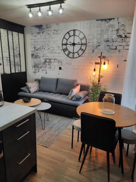 uma sala de estar com um sofá e uma mesa em Le MAGDAD em Rochefort