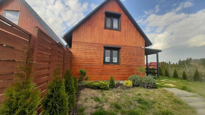 ein großes Holzhaus mit einem Zaun davor in der Unterkunft Domek letniskowy Ada, Gabrysia, Alan Wieleń in Osłonin