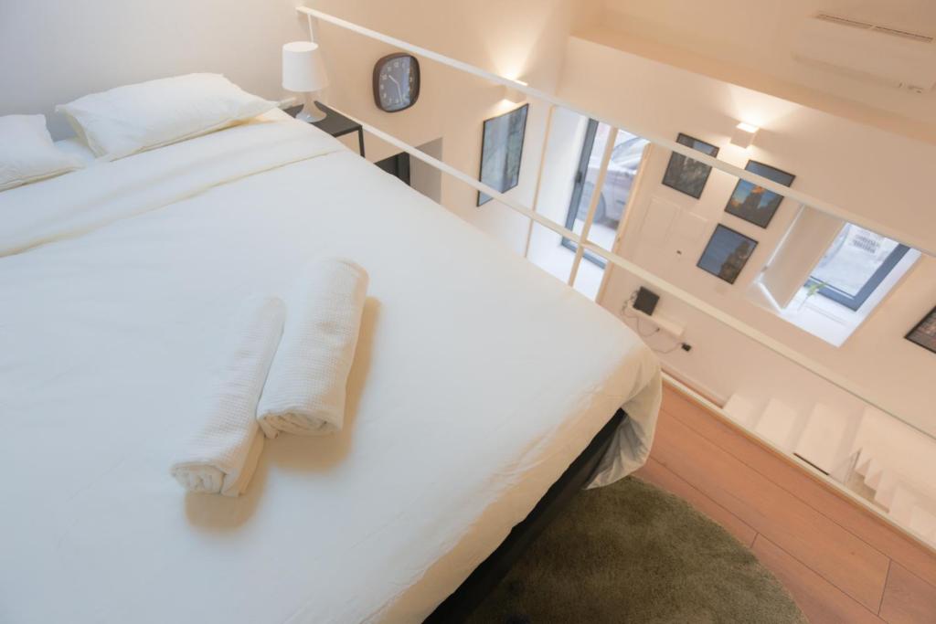 una camera da letto con un grande letto bianco con cuscini bianchi di FIVE HOUSE 18 a Porto