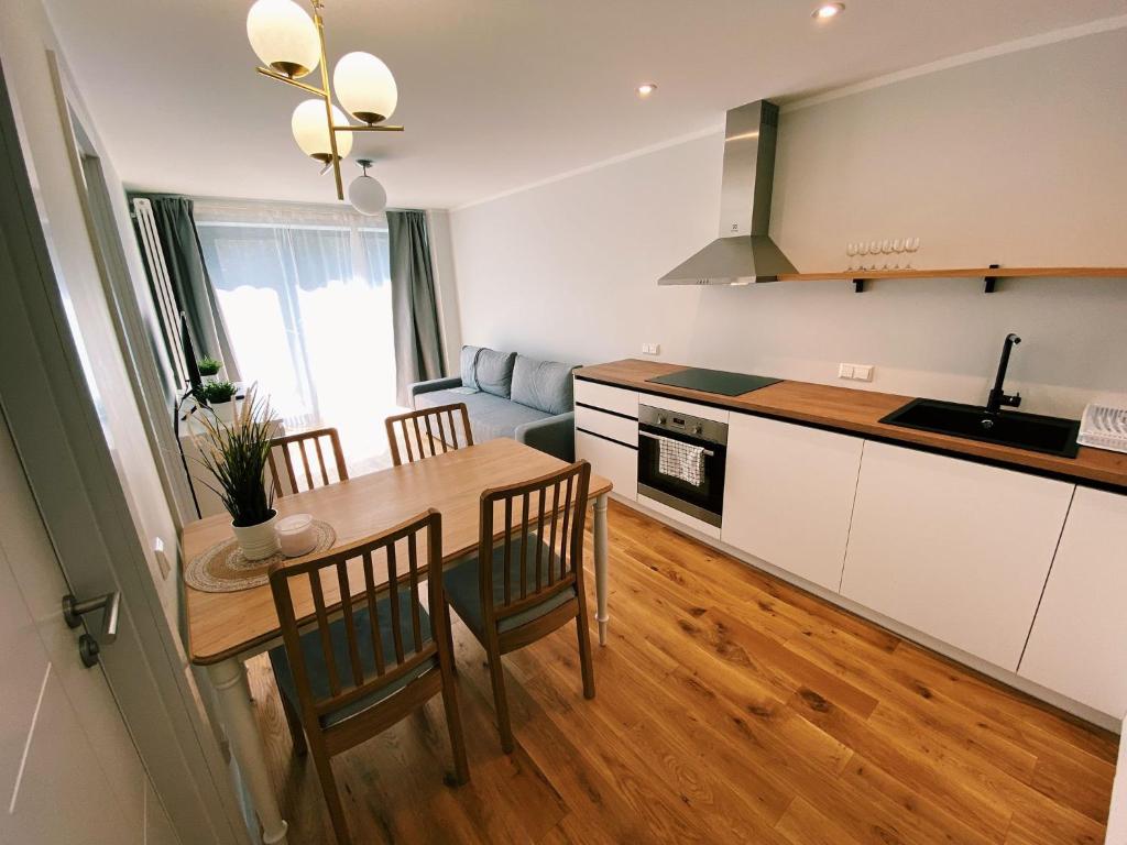eine Küche und ein Esszimmer mit einem Tisch und Stühlen in der Unterkunft Albatross Mini - 2 Room Seaside Air-conditioned Apartment with Balcony in Ķesterciems