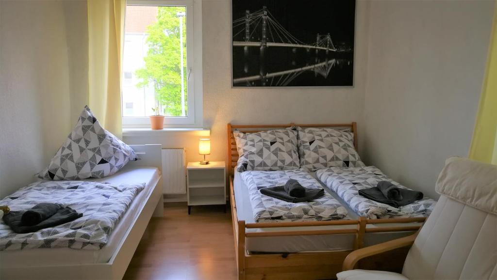 - une chambre avec 2 lits et une fenêtre dans l'établissement Apartment am Südpark, à Merseburg