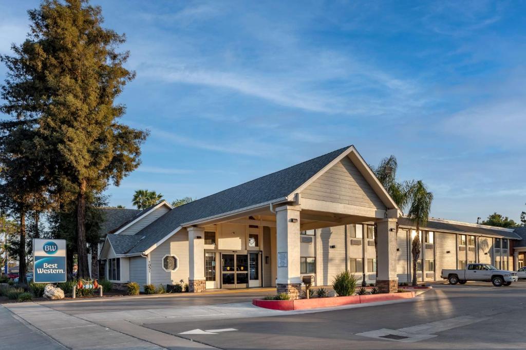 un edificio en un estacionamiento con un concesionario en Best Western Town & Country Lodge en Tulare
