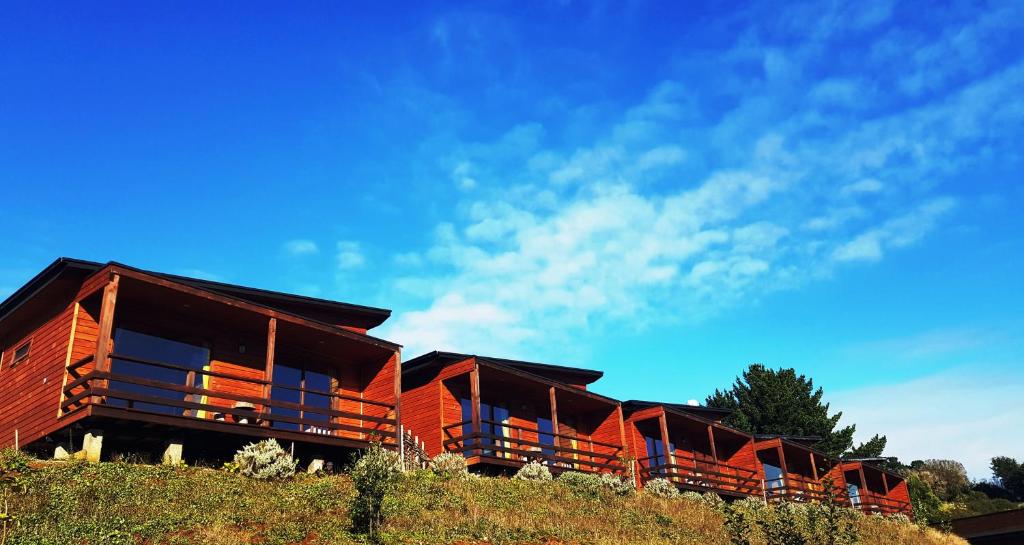 a row of cabins on the side of a hill at Hotel y Cabañas Terrazas Vista al Mar hct in Ancud