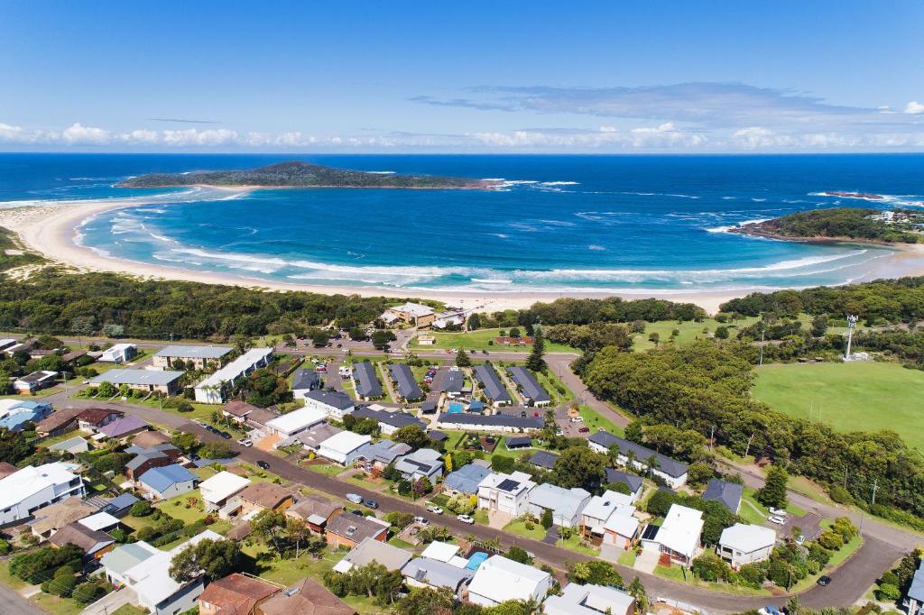 an aerial view of a town and the beach at Seaside Holiday Resort in Fingal Bay
