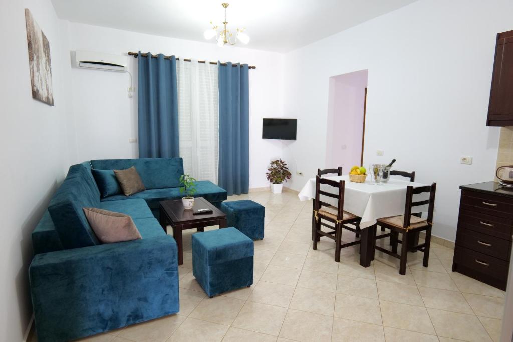 sala de estar con sofá azul y mesa en Ernest Apartments, en Sarandë