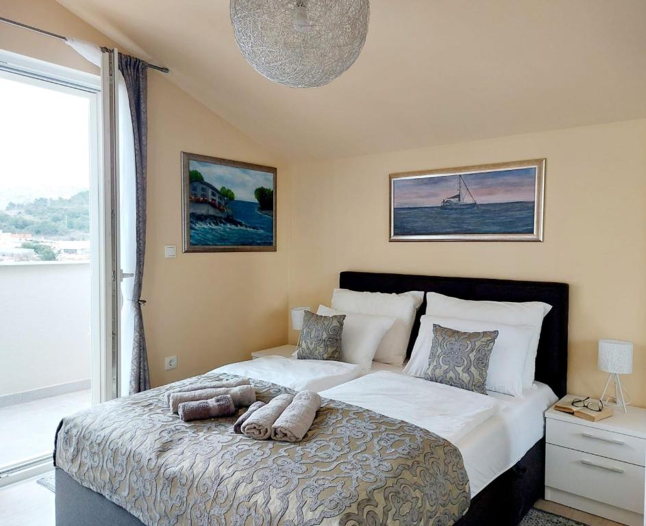 a bedroom with a large bed and a large window at Apartman Stella Marina in Šibenik
