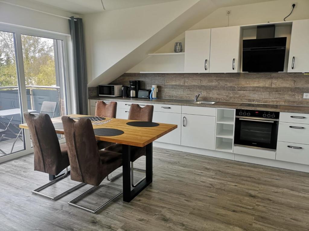 a kitchen with a wooden table and chairs in a room at Ferienwohnung Nord/Süd in Nordenham