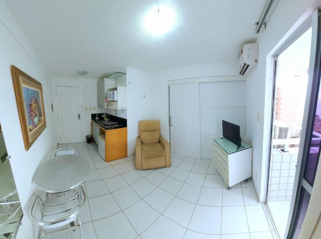a white room with a table and a chair at American Flat - Ponta D'areia - Ferreira Hospedagens in São Luís