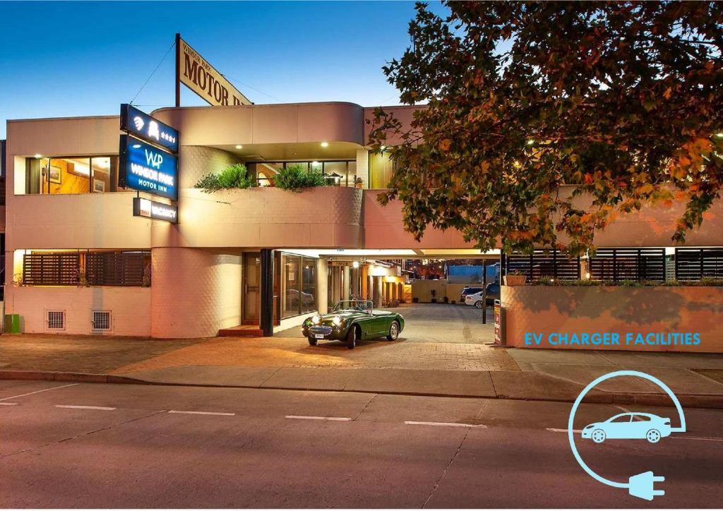 a street scene with a car parked in front of a building at Winsor Park Motor Inn in Albury