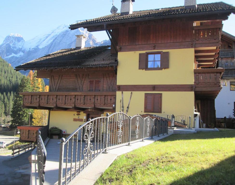 a house with a fence in front of it at B&B Cesa Marlen in Canazei