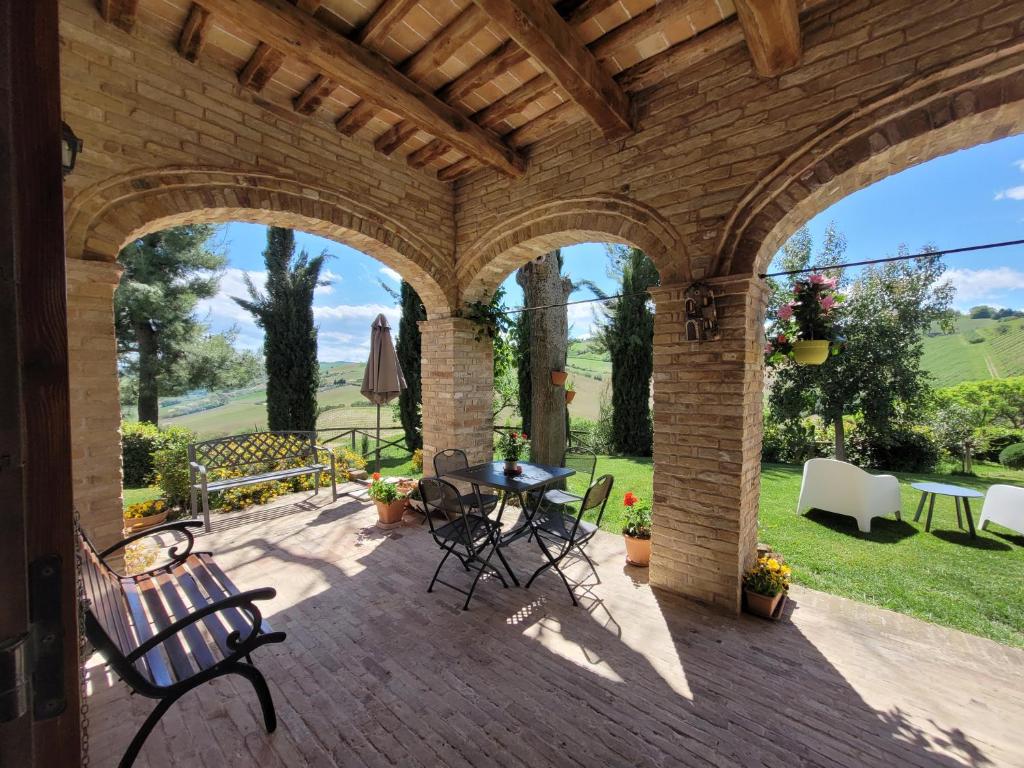 eine Außenterrasse mit einem Tisch und Stühlen in der Unterkunft Agriturismo Fiorano in Cossignano