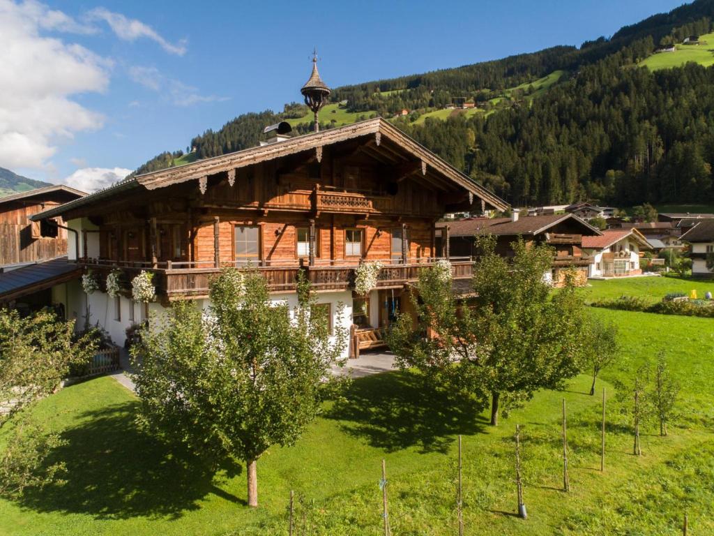 uma grande casa de madeira num campo com árvores em Blick zum Mayrhofen em Ramsau im Zillertal