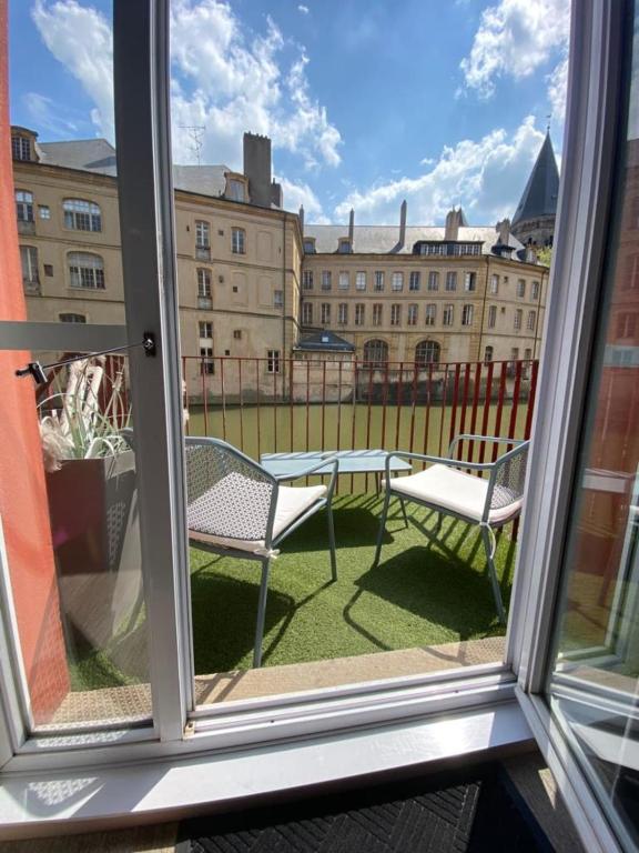 - une vue depuis la fenêtre d'une terrasse avec une table et des chaises dans l'établissement Romantique 