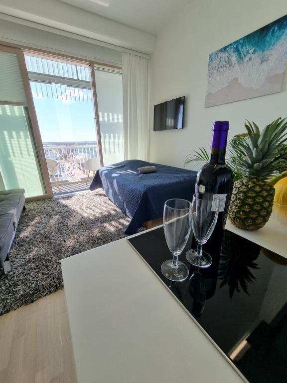 a room with a bottle of wine and two glasses at Penthouse in the Oulu center in Oulu