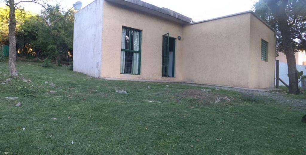 a small house with a grass yard in front of it at Casita de la montaña in Río Ceballos