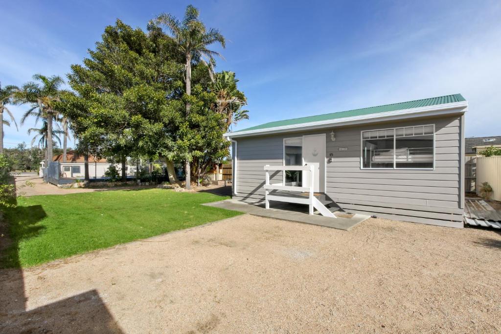 a small house with a porch and a yard at The Beaches on Lakes Cottage - Cosy Coastal Escape in Lakes Entrance