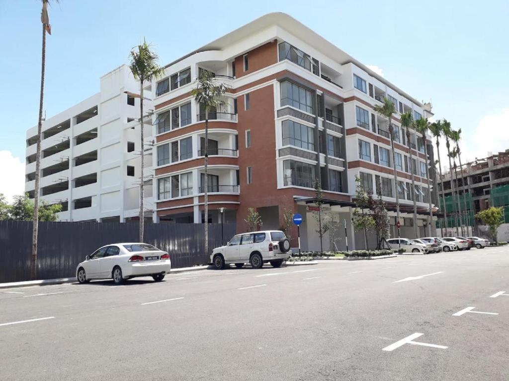 米里BS Homestay1 - 1 Bedroom Apartment in Miri Times Square的建筑物前停放汽车的停车场