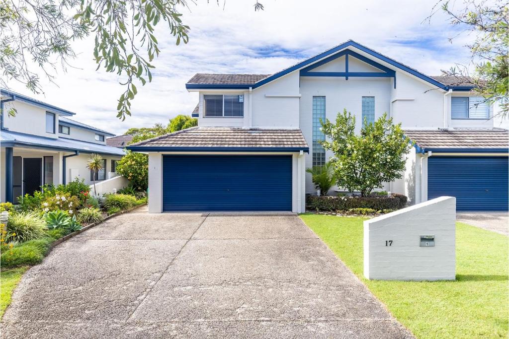 a house with blue garage doors in a yard at Sea Whispers 1 Just a short stroll to the beach in Fingal Bay