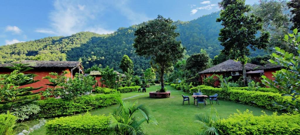 a garden with tables and chairs and mountains in the background at Maatre Yoga Retreat in Marchula