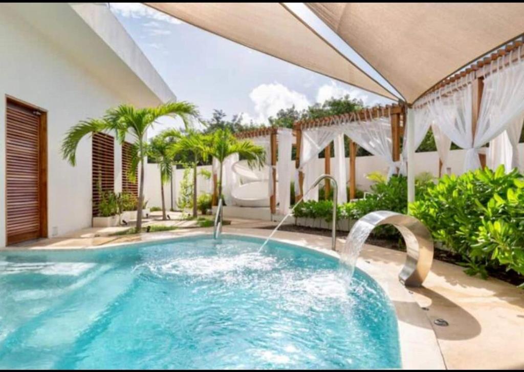 an outdoor swimming pool with a hot tub at Central Park ModernStudio, Gym, Spa, Wi-Fi, cowork in Tulum