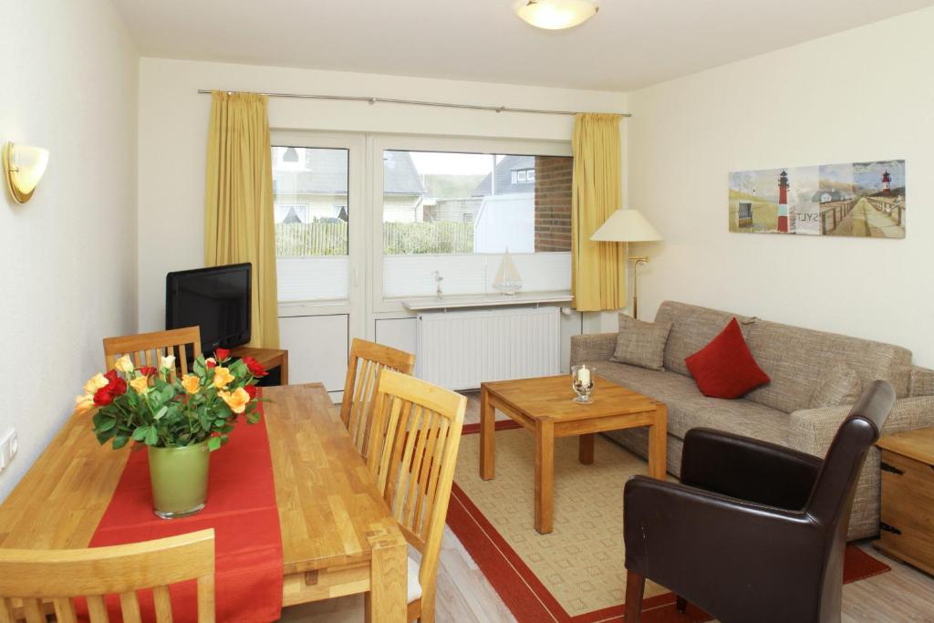 uma cozinha e sala de estar com uma mesa e um sofá em Ferienwohnung Mare Nostrum 8 em Westerland