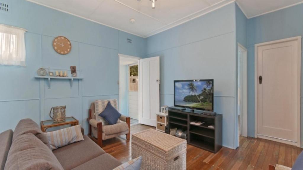 a living room with a couch and a television at Happy Ours - Patonga Beach in Patonga