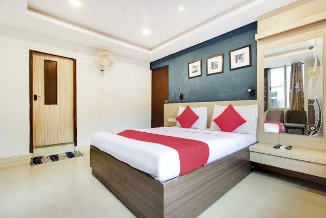 a bedroom with a large bed with red pillows at S K RESIDENCY in Bangalore