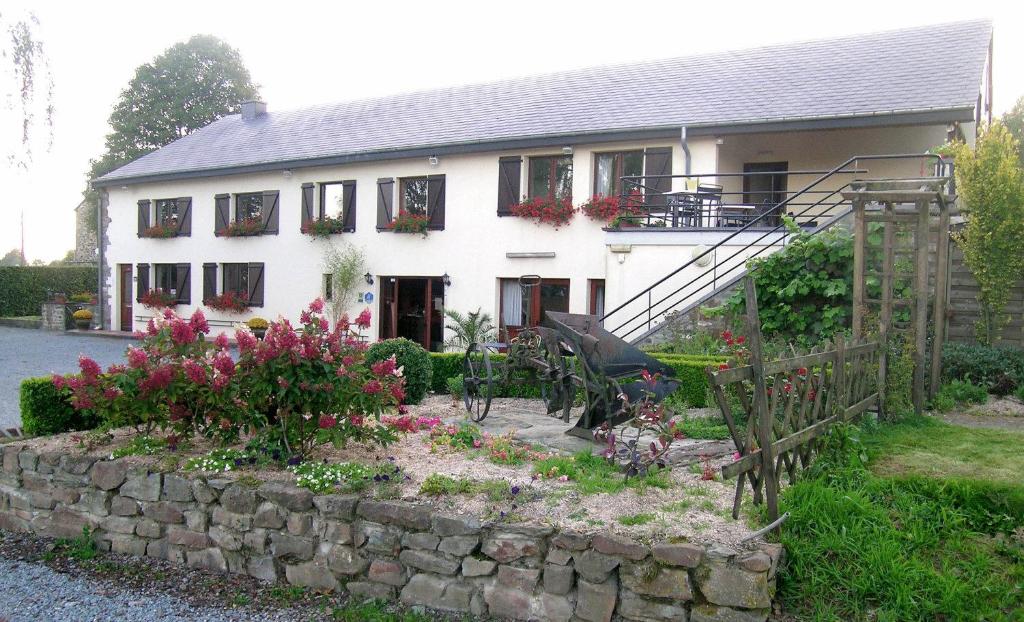 een huis met een bloementuin ervoor bij Hotel La Crémaillère in Bras-Haut